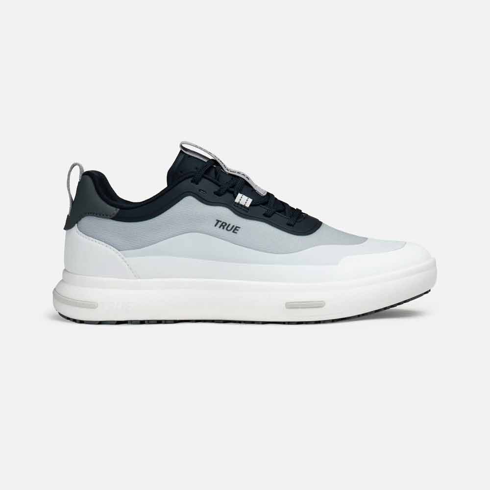A modern sneaker-inspired golf shoe from True Linkswear with a white and gray gradient upper, thick white sole, black heel, and black laces. The word TRUE is printed on the side. Designed as comfortable golf shoes for everyday wear.