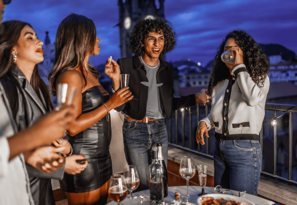 Multiracial stylish friends dancing and drinking champagne during night party